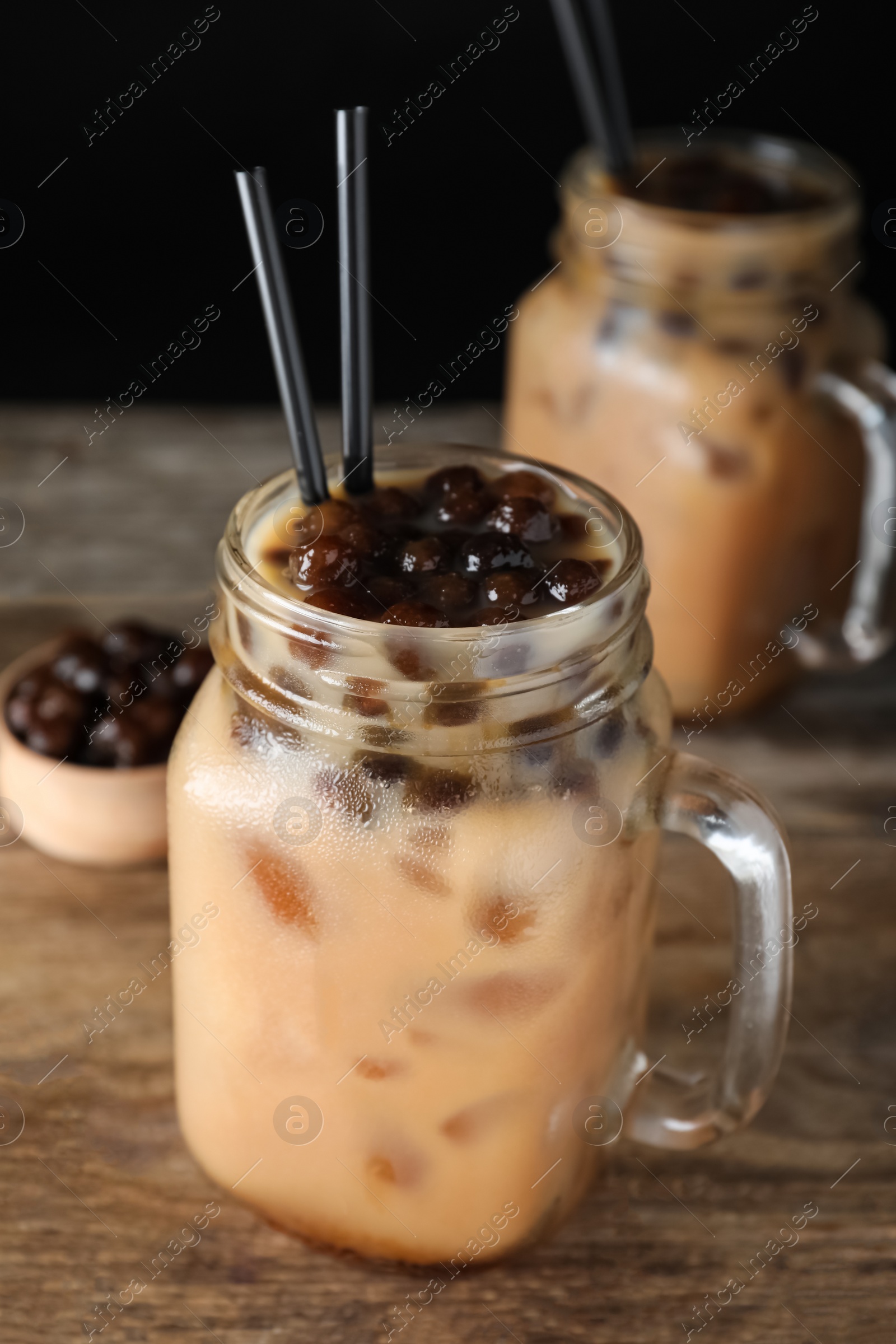 Photo of Tasty milk bubble tea on wooden table, closeup