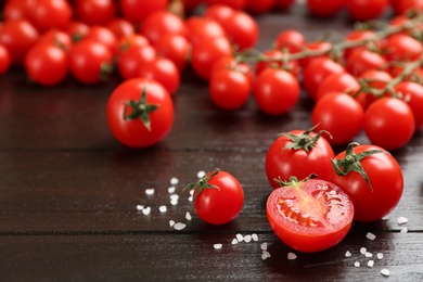 Fresh cherry tomatoes and sea salt on wooden table