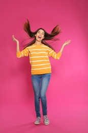 Photo of Full length portrait of emotional woman on color background