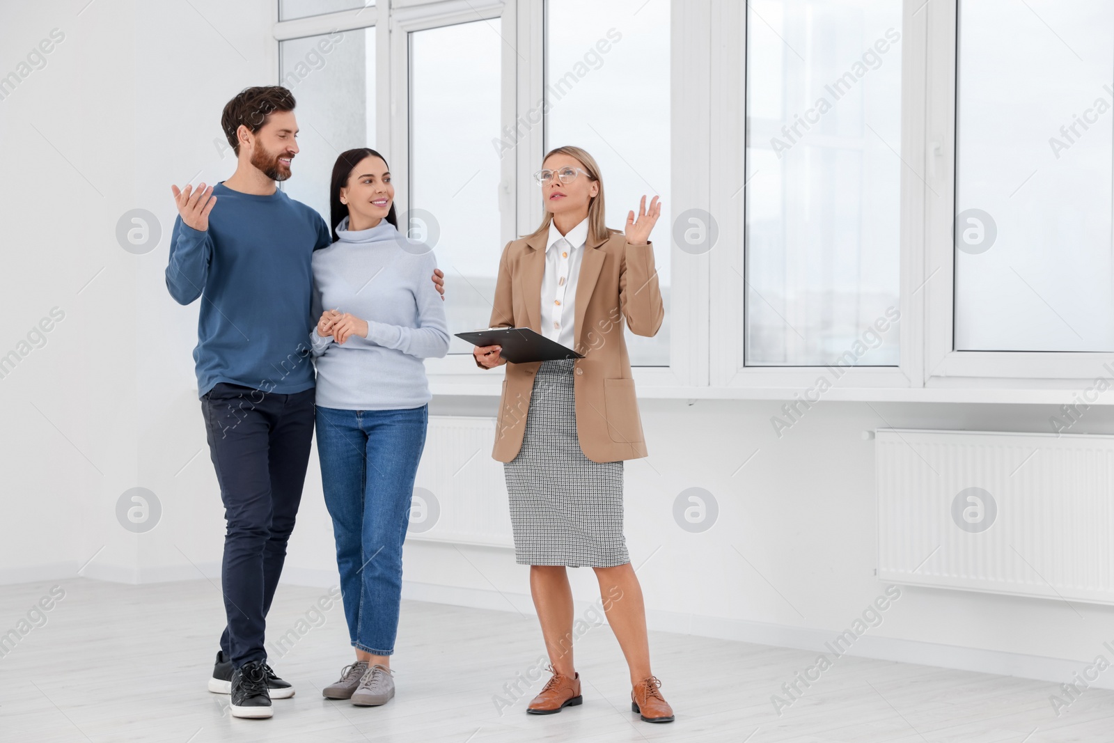 Photo of Real estate agent showing new apartment to couple