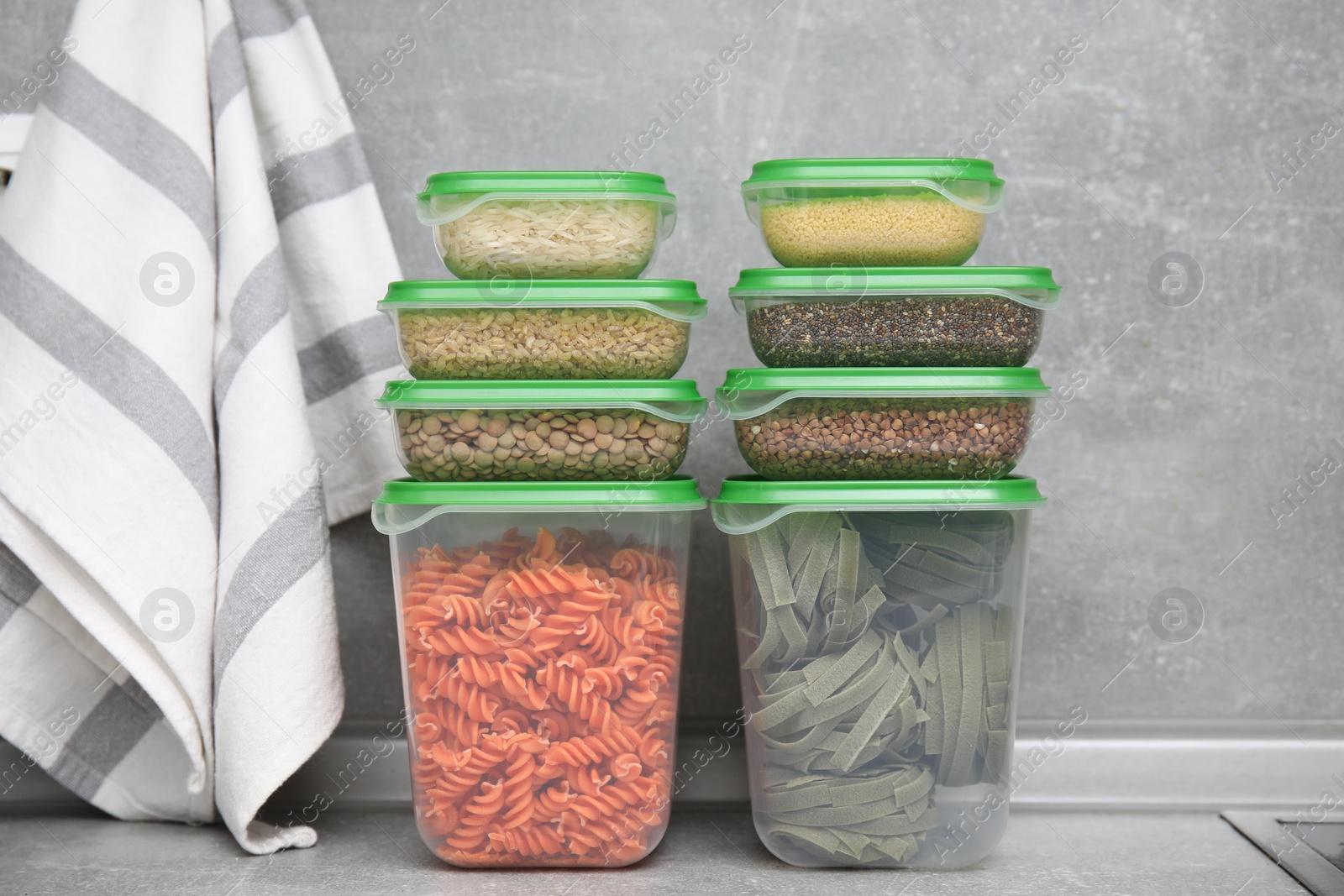 Photo of Plastic containers filled with food products on grey table