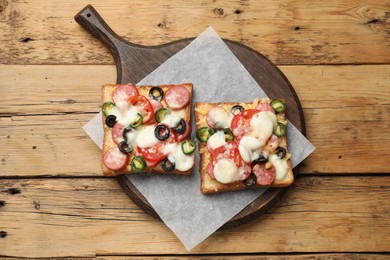 Tasty pizza toasts on wooden table, top view