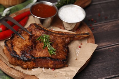 Photo of Tasty marinated meat, rosemary and spices on wooden table, closeup