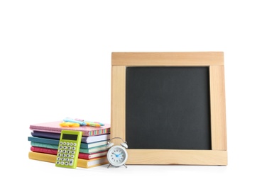 Photo of Different school stationery and small blank chalkboard on white background. Space for text