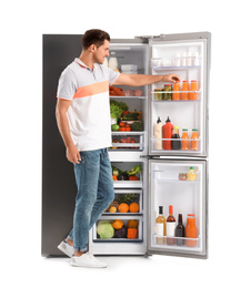 Man taking juice from refrigerator on white background