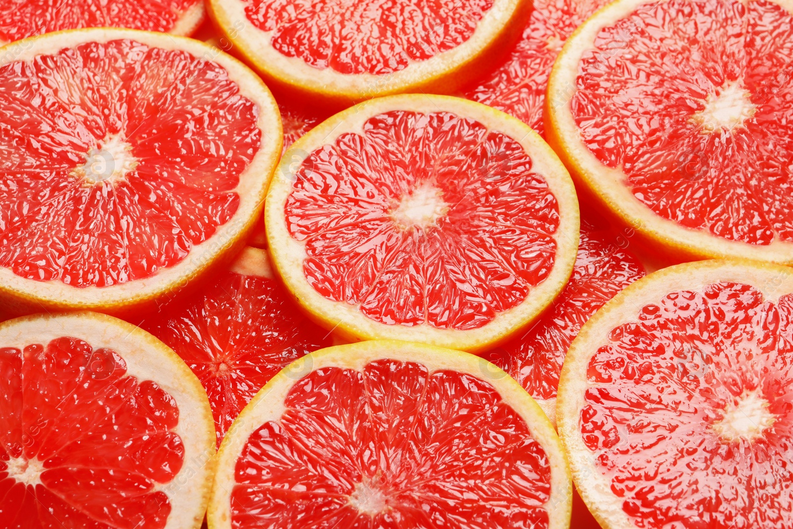 Photo of Juicy grapefruit slices as background. Citrus fruit