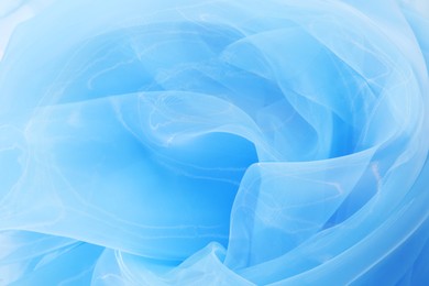 Photo of Beautiful light blue tulle fabric as background, closeup