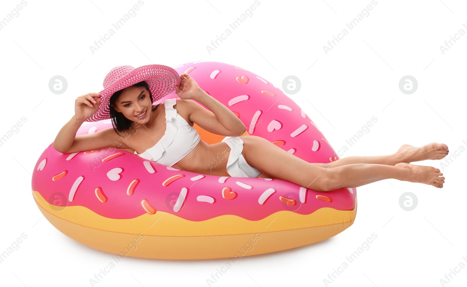 Photo of Beautiful young woman in stylish bikini with hat and inflatable ring on white background