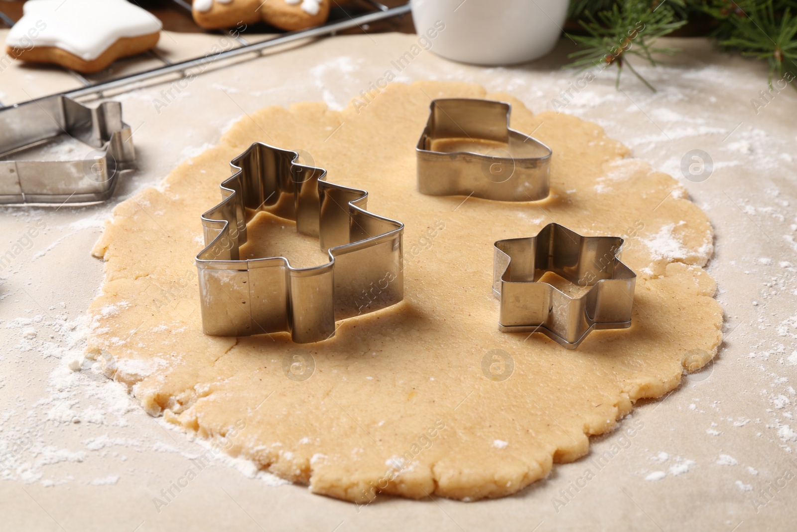 Photo of Making Christmas cookies. Raw dough and different metal cutters on table