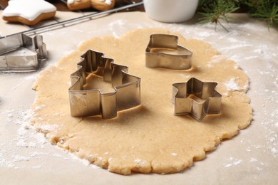 Photo of Making Christmas cookies. Raw dough and different metal cutters on table