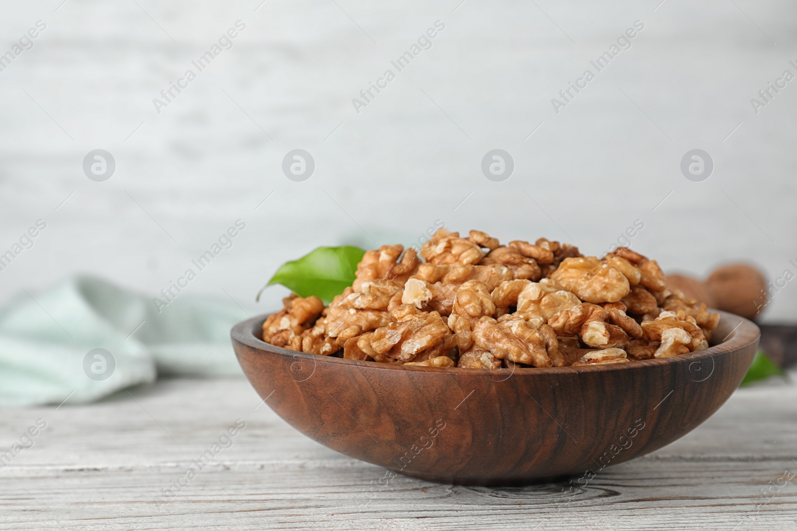 Photo of Plate with tasty walnuts on wooden table