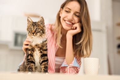 Photo of Young woman with cat at home. Owner and pet