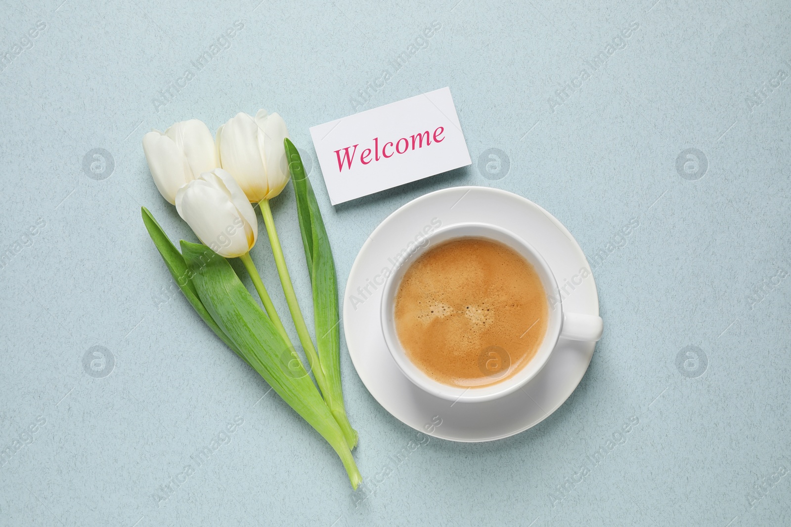 Image of Welcome card, beautiful white tulips and cup of aromatic coffee on pale light blue background, flat lay