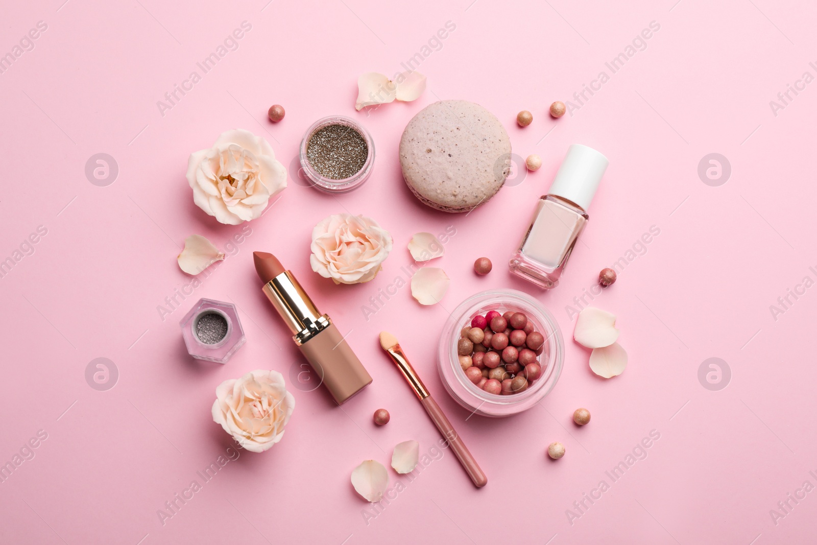 Photo of Flat lay composition with makeup products, roses and macaron on pink background