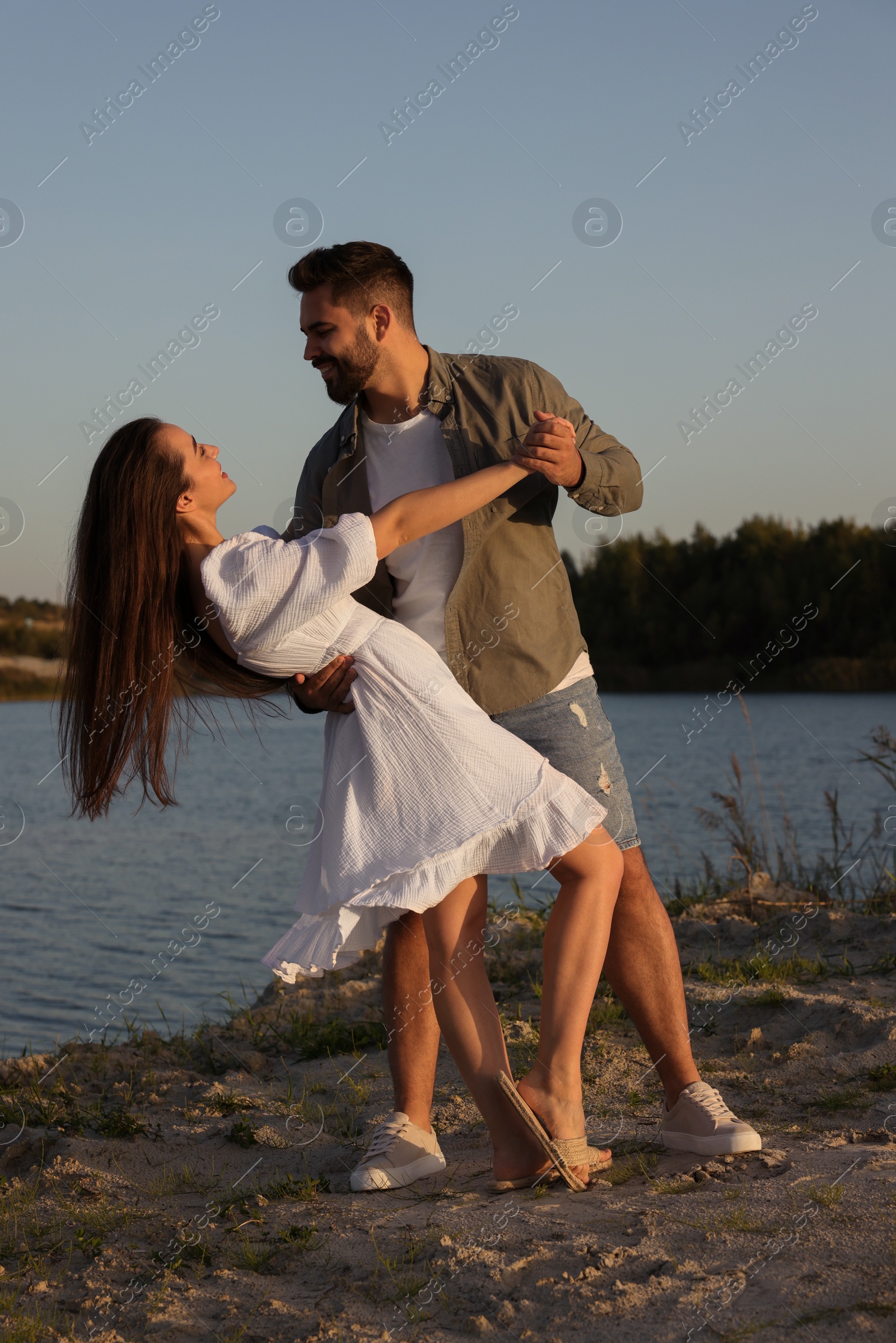 Photo of Beautiful couple dancing near river at sunset