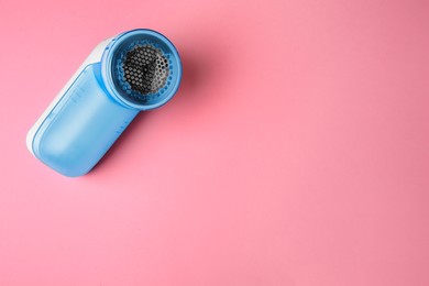 Photo of Modern fabric shaver on pink background, top view. Space for text
