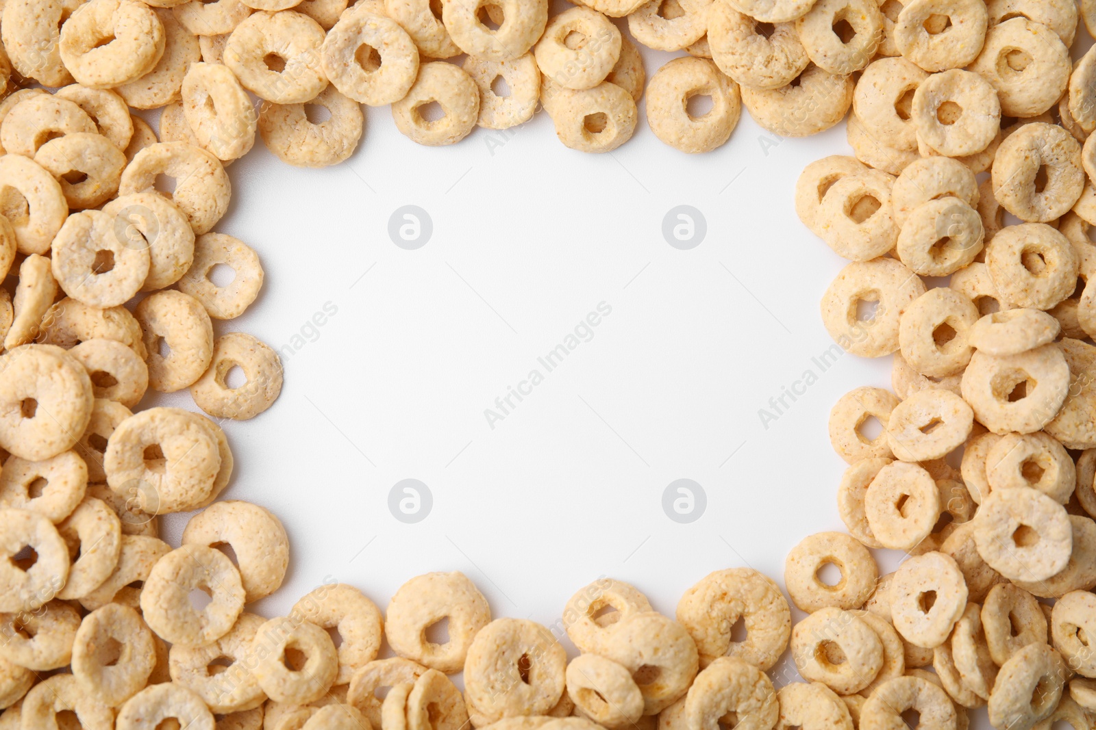 Photo of Frame made of cereal rings on white background, top view. Space for text