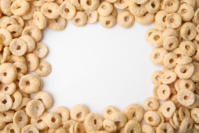 Photo of Frame made of cereal rings on white background, top view. Space for text