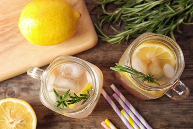 Flat lay composition with lemon and rosemary cocktail on wooden table