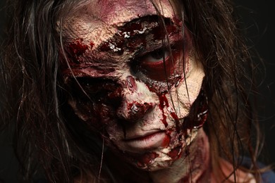 Photo of Scary zombie on dark background, closeup. Halloween monster