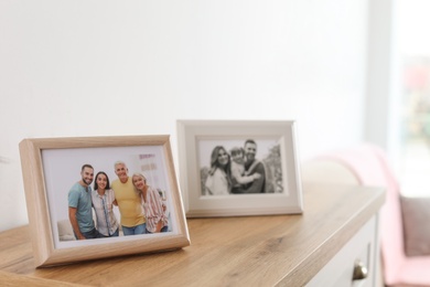 Family portraits in frames on cabinet indoors