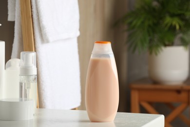 Bottle of shampoo and toiletries on white table in bathroom