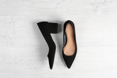 Pair of female shoes on wooden background, top view