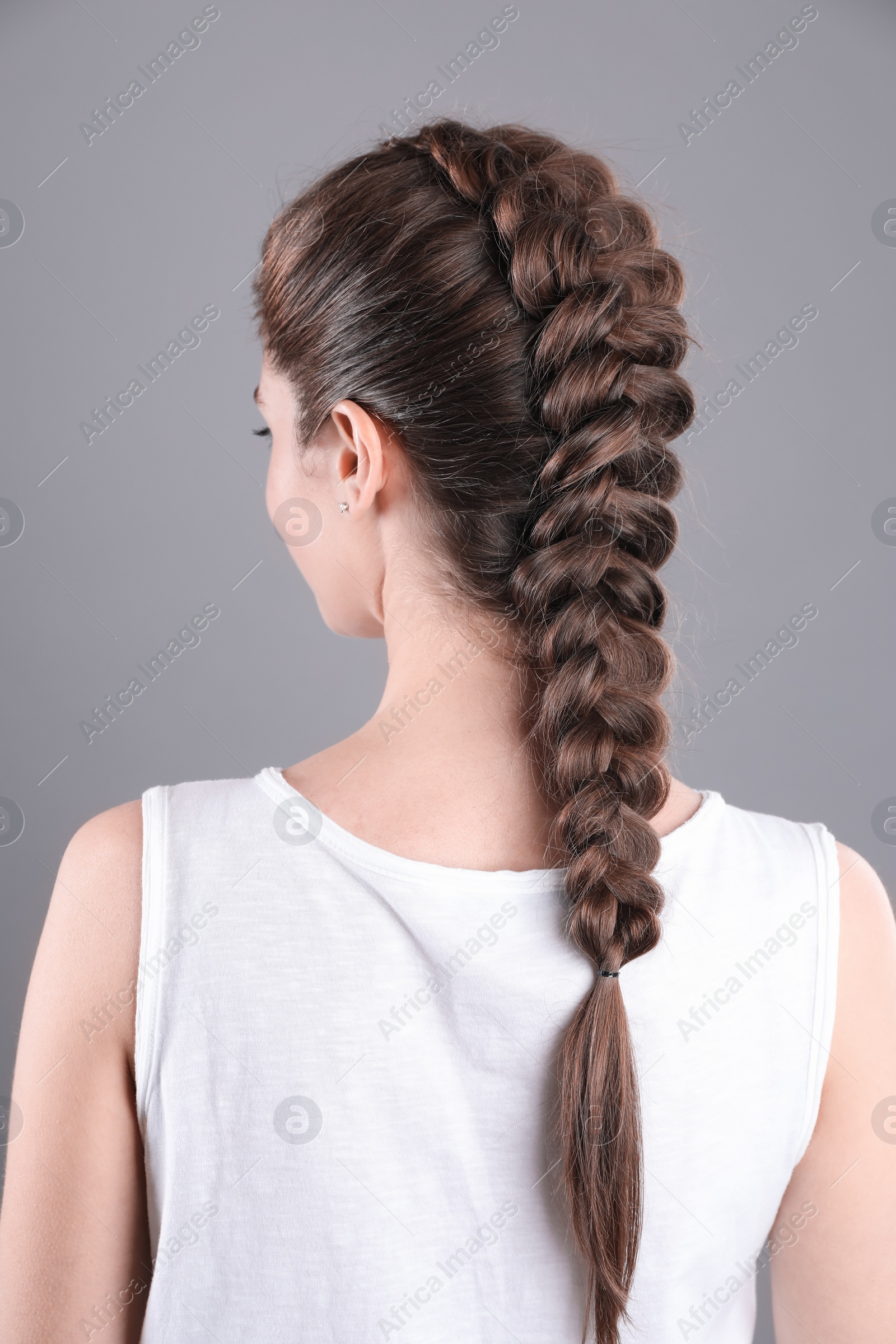 Photo of Woman with braided hair on grey background, back view