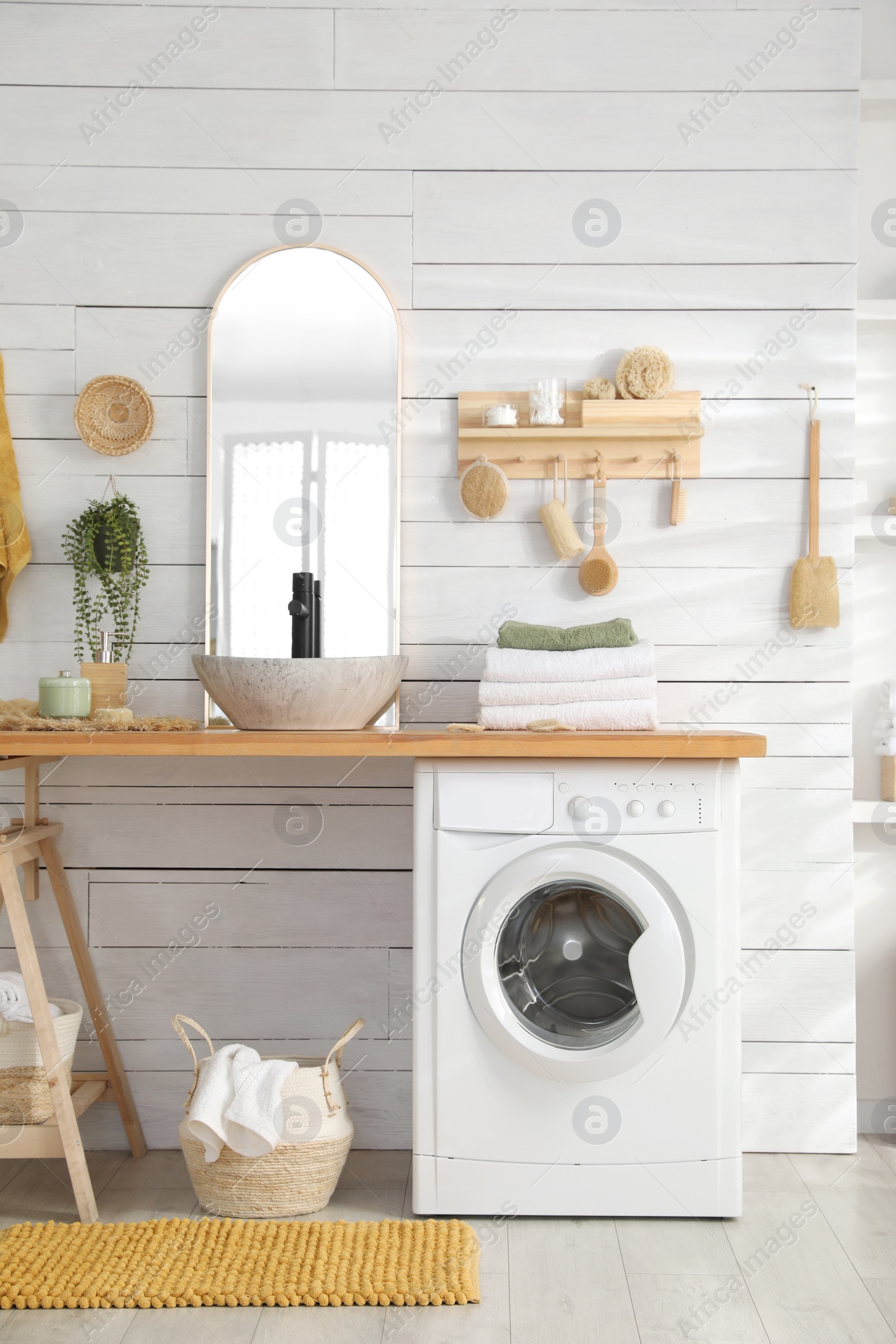 Photo of Stylish bathroom interior with modern washing machine