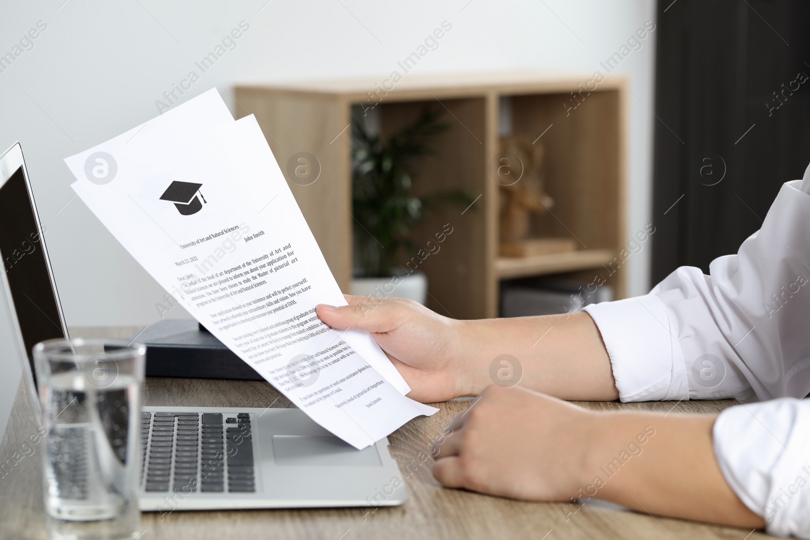 Photo of Student with acceptance letters from universities at wooden table indoors, closeup