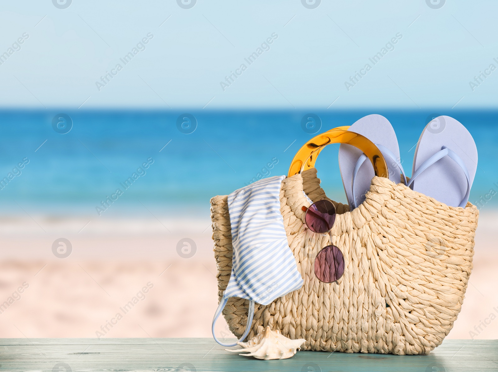 Image of Different beach objects on wooden surface near sea, space for text