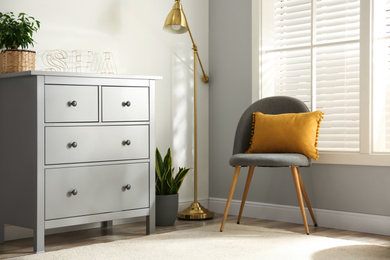 Grey chest of drawers in stylish room interior