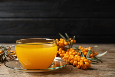 Fresh sea buckthorn tea on wooden table