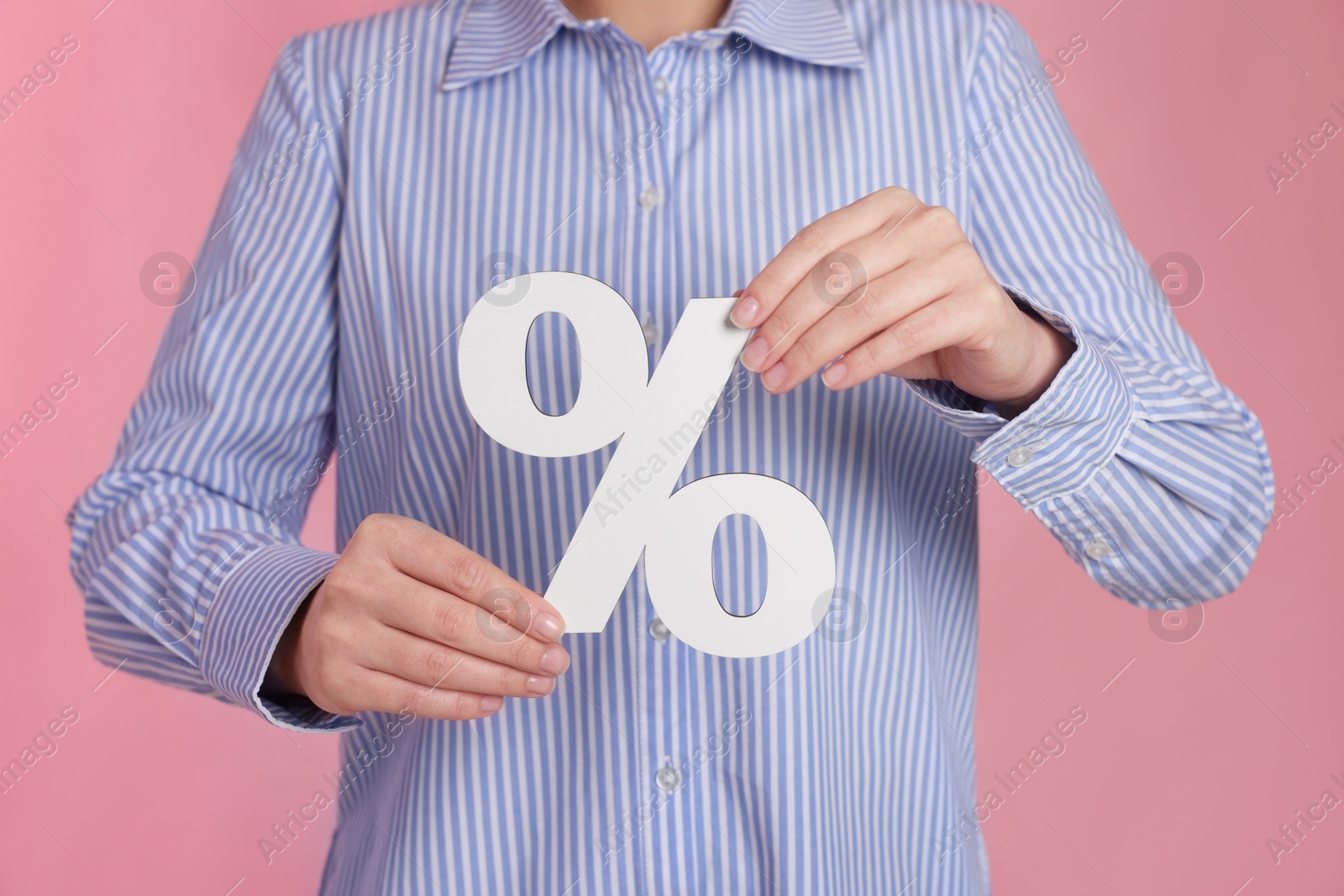 Photo of Woman holding percent sign on pink background, closeup