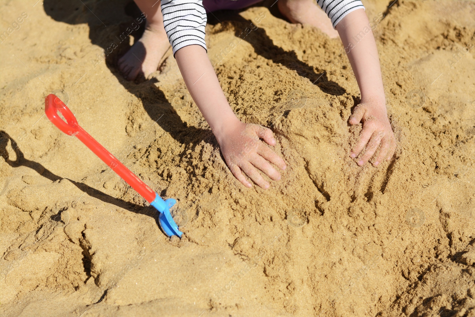 Photo of Child making sand castle on beach, closeup