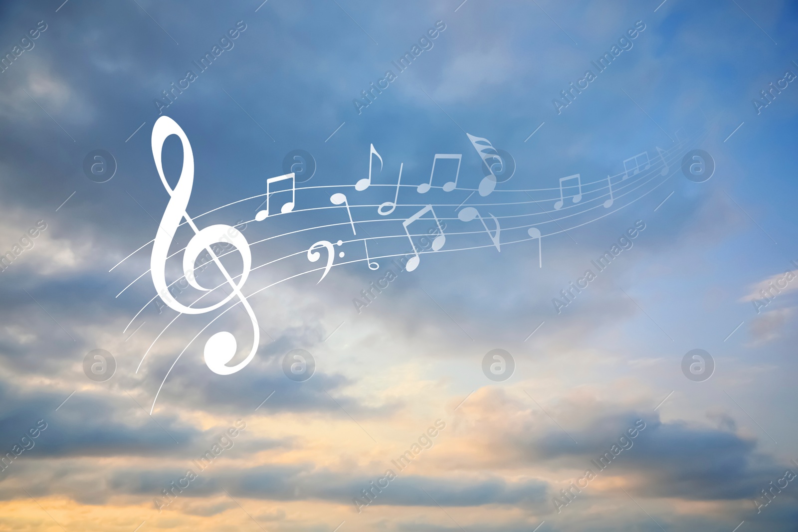 Image of Staff with treble clef and musical notes against sunset sky