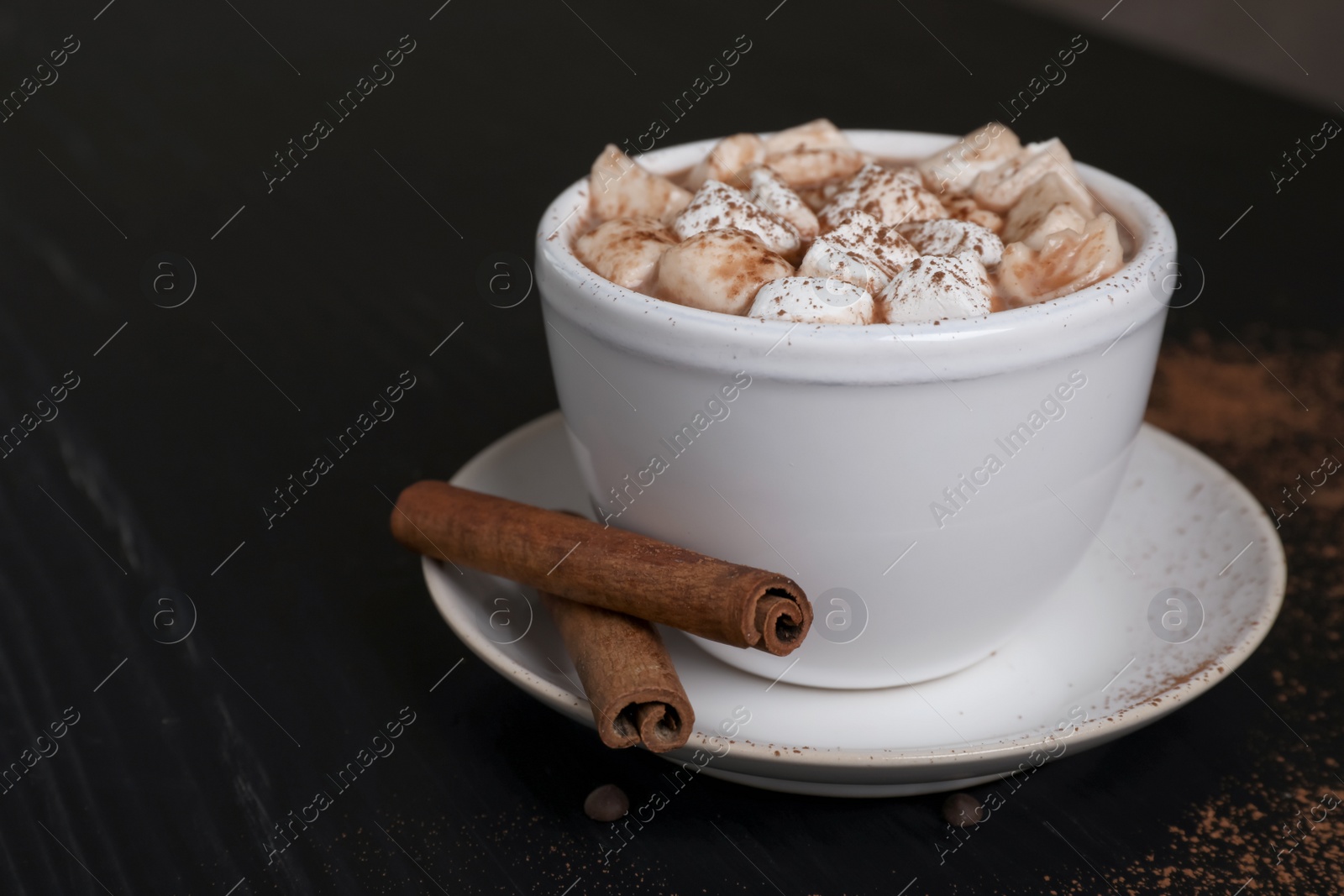 Photo of Tasty hot chocolate with milk and marshmallows in cup on table