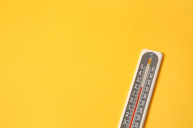Photo of Weather thermometer on yellow background, above view. Space for text