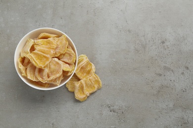 Photo of Delicious dried jackfruit slices on light grey table, flat lay. Space for text