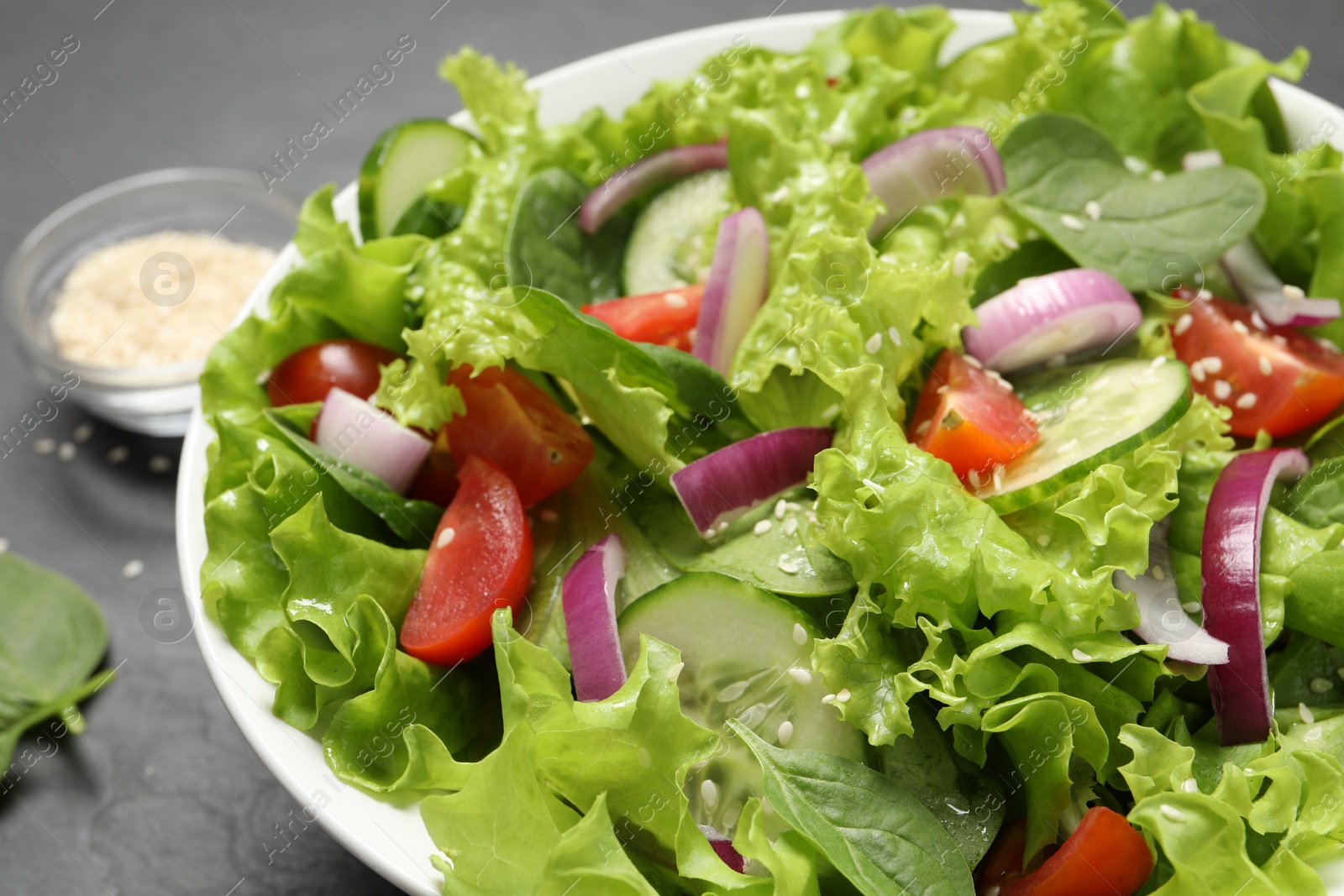 Photo of Delicious salad in bowl on grey table, closeup