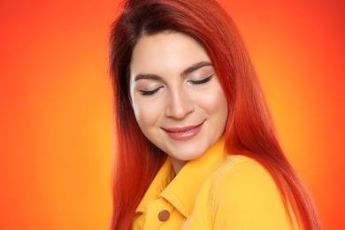 Photo of Young woman with bright dyed hair on color background