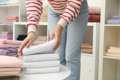 Photo of Woman choosing towels in home textiles store, closeup