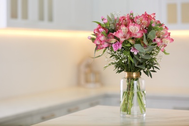 Photo of Vase with beautiful alstroemeria flowers on table in kitchen, space for text. Interior design