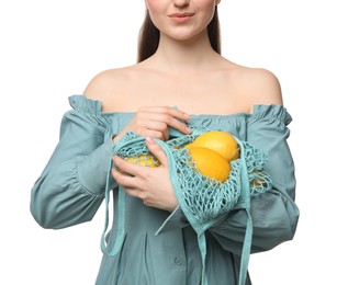Woman with string bag of fresh lemons on white background, closeup
