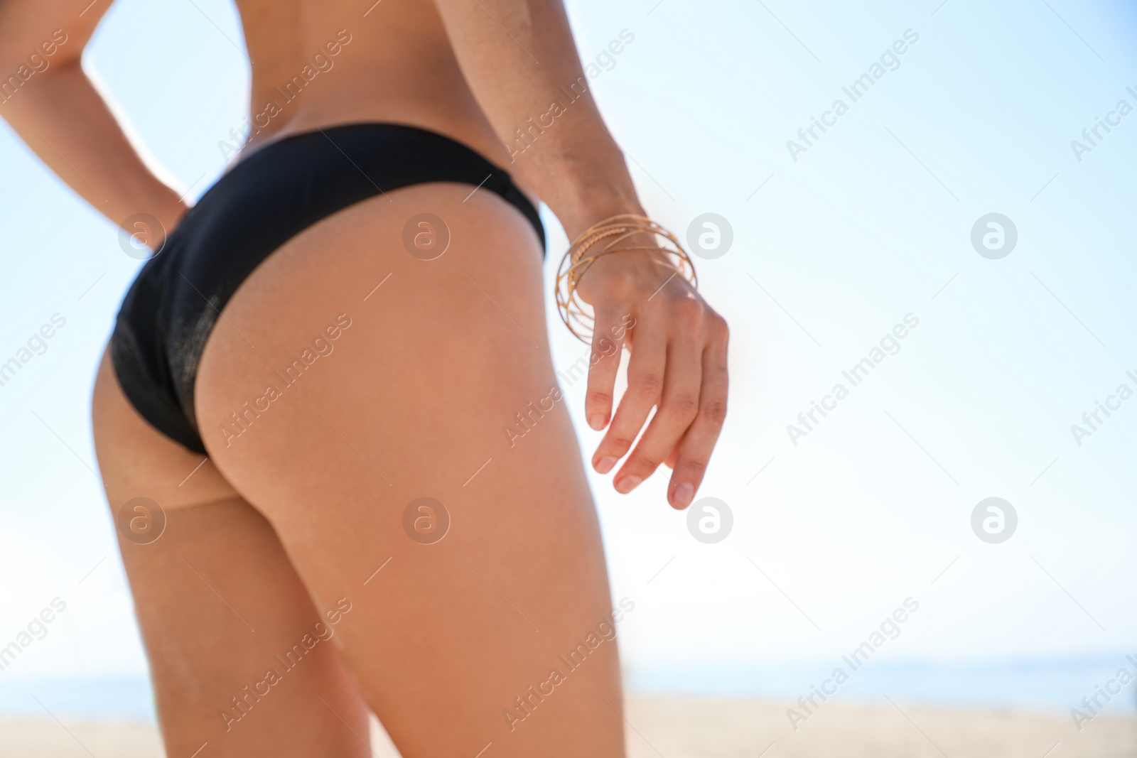 Photo of Young woman with beautiful body on beach, closeup