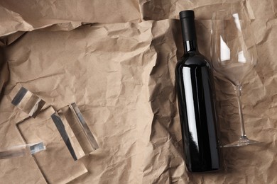 Photo of Stylish presentation of delicious red wine in bottle and glass on paper background, top view. Space for text