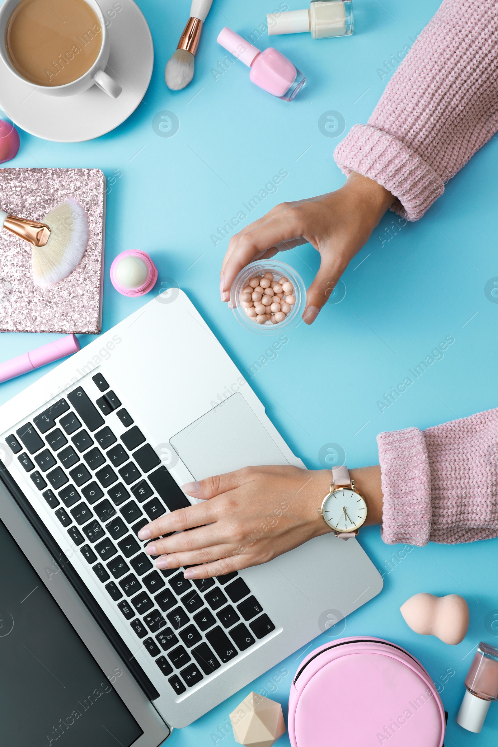 Photo of Young beauty blogger with laptop and accessories on light blue background, top view