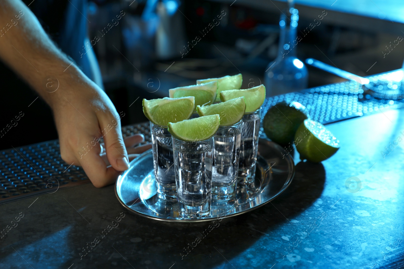 Photo of Bartender with shot glasses of Mexican Tequila at bar counter, closeup