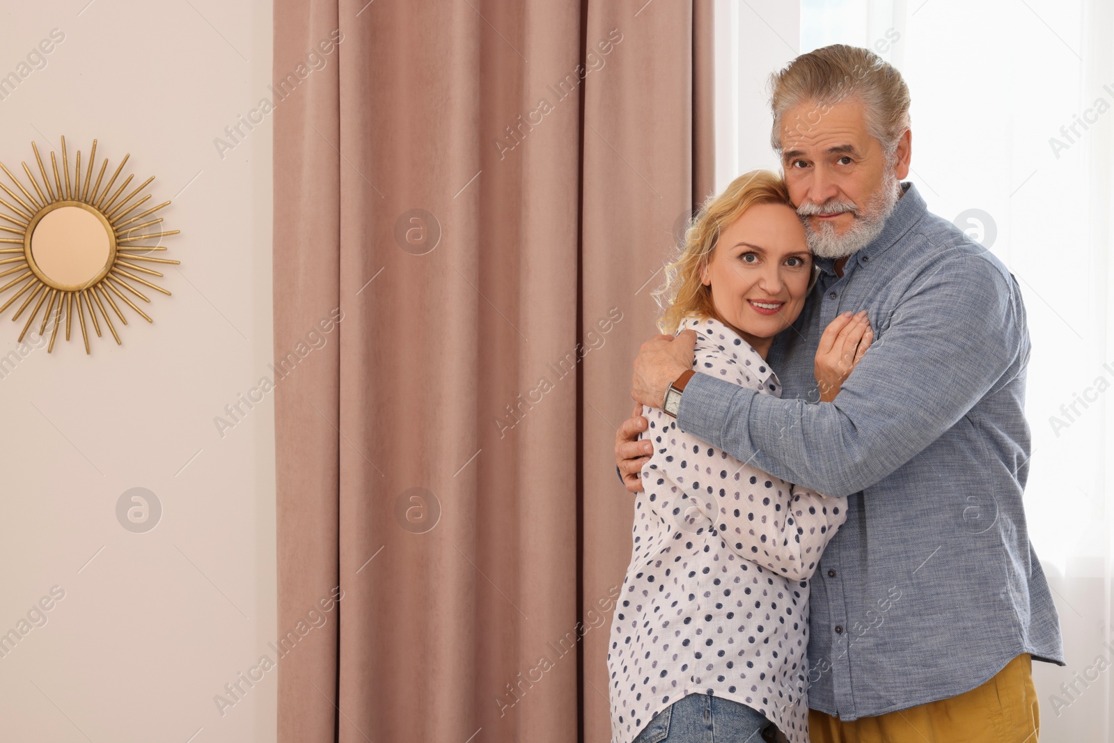 Photo of Happy mature couple hugging at home. Dating agency