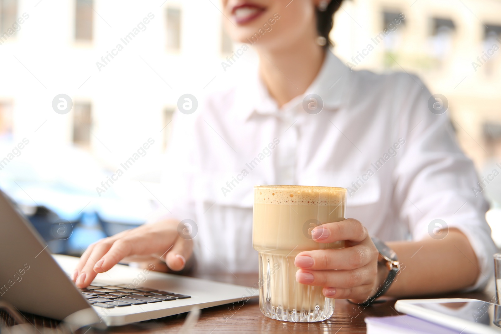 Photo of Young woman working with laptop at desk, closeup